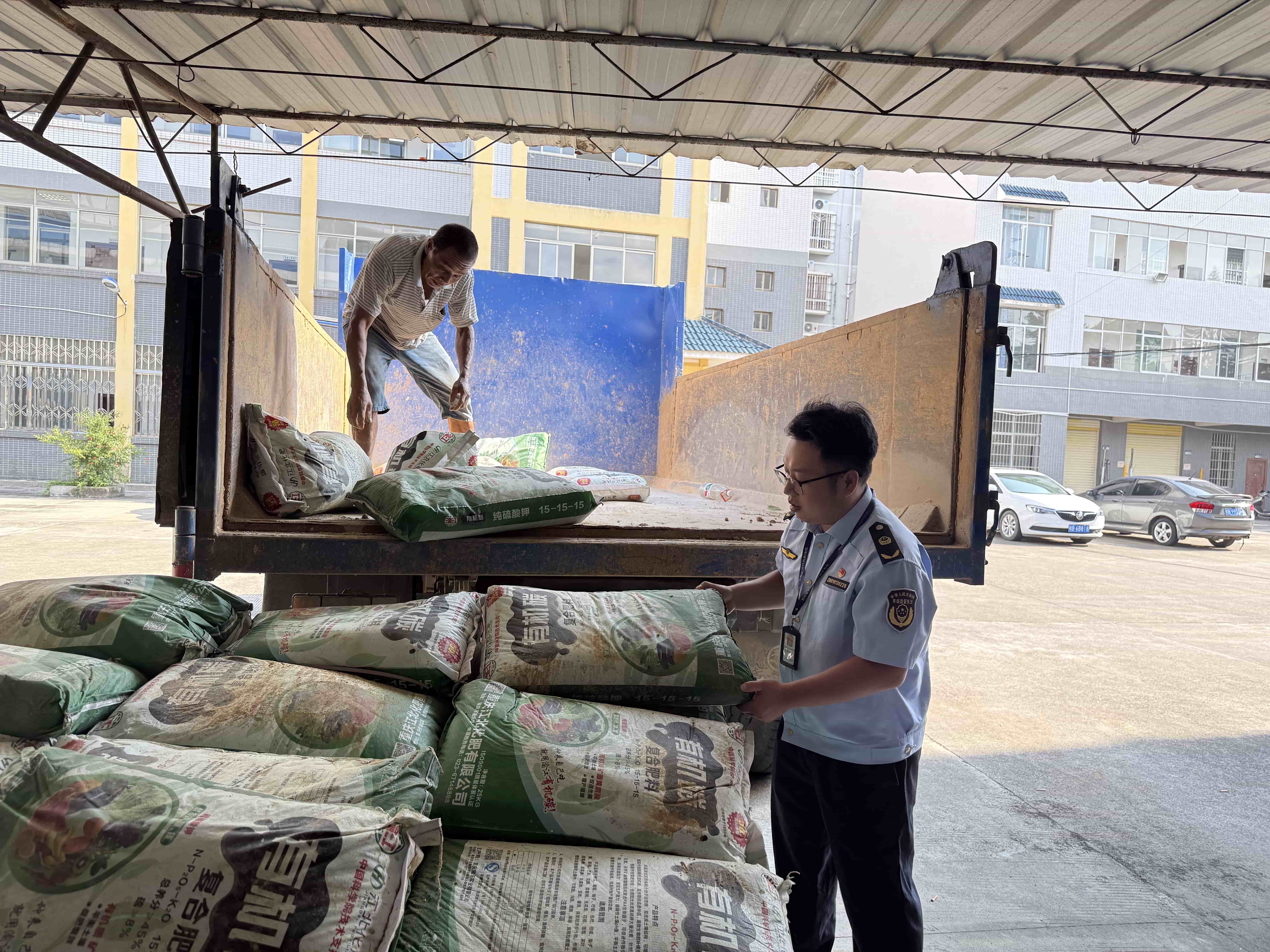工作人员搬运伪劣化肥.jpg